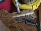 a broom and a brush on the floor next to a bucket