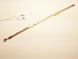 a close up of a gold bracelet with a chain attached to it
