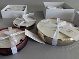 several boxes of candles are wrapped in white ribbons on a table