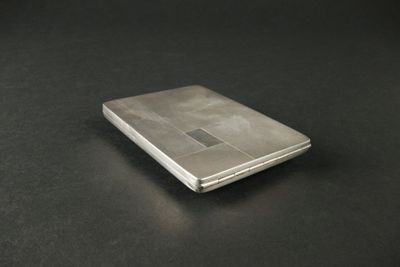 un téléphone portable argenté posé sur une table noire