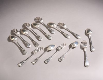 a lot of silver spoons and forks laid out on a table