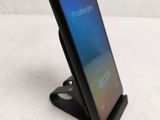 a close up of a phone on a stand on a white surface
