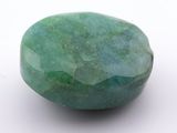 a close up of a green stone on a white surface