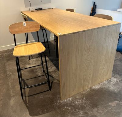 two stools sitting at a table with a computer on it