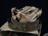 a bowl of newspaper sitting on top of a grill