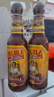 two bottles of hot sauce sitting on top of a table