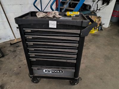 a black tool box with tools on it in a garage