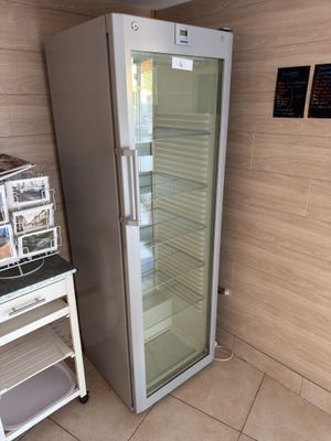 un réfrigérateur situé à côté d'une petite table dans une pièce