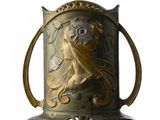 un vase en or orné d'un visage de femme