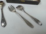 three forks and two spoons and a box on the table