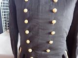 a black uniform with gold buttons on it