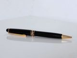 a close up of a pen on a table with a white background