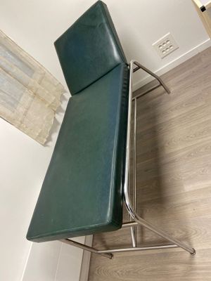 une chaise verte qui se trouve dans un coin de la pièce