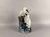 two birds that are sitting on top of a rock