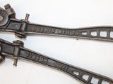 pair of old adjustable wrenets sitting on top of a white surface