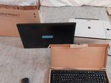 deux ordinateurs portables et un clavier dans une boîte posée par terre