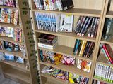 a bookshelf filled with books and magazines in a room