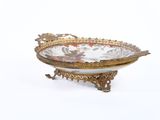 a gold and white bowl on a stand on a white surface