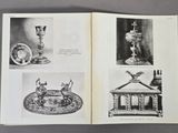 an open book with pictures of antique items on a table