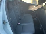 sur la banquette arrière d'une voiture blanche dont la portière est ouverte