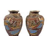 pair of asian vases with dragon designs on them against a white background