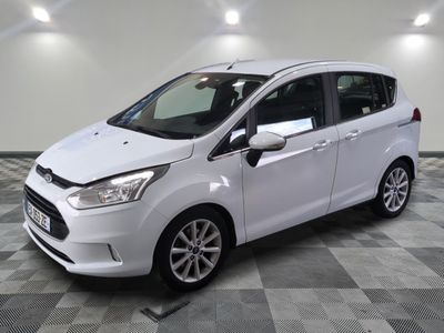 Une Ford C-Max blanche est garée sur un sol à damier