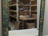 un miroir posé sur une table devant une étagère