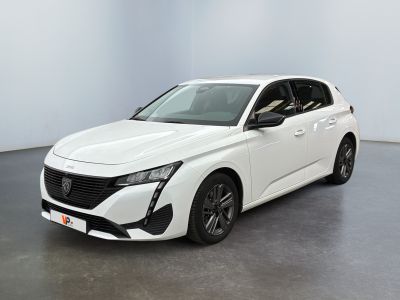 Une voiture blanche est garée dans une pièce au sol gris.