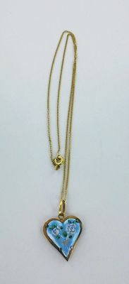 a close up of a necklace with a blue heart on it