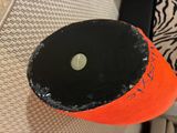 a black and orange hat with a hole in it