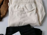 a white shirt and black pants on a white table