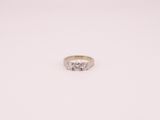 une bague de fiançailles ornée de trois diamants sur fond blanc