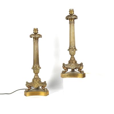 une paire de bougies anciennes en laiton sur des socles, sur fond blanc