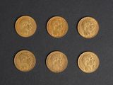 six types différents de pièces d'or sur une surface noire