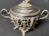an antique silverplated bowl with a lid on a black surface