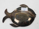 a silver plate with a fish on it on a table