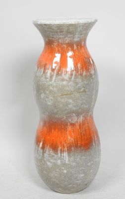 un vase blanc et orange posé sur une surface blanche