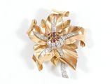 une image représentant une broche en or sertie de diamants et ornée d'une fleur