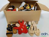 de nombreuses paires de chaussures dans une boîte en carton posée sur une table