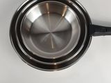 a metal saucepan with a lid on a white table