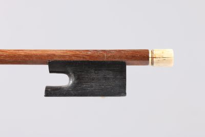 un vieil archet de violon avec un manche en bois sur fond blanc
