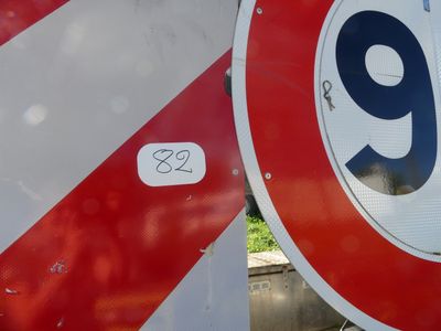 a red and white sign with the number nine on it