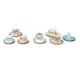 un ensemble de tasses à thé et de soucoupes miniatures posées sur une surface blanche