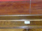 a wooden chest of drawers with a phone on top of it