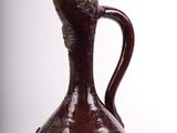 a brown vase that is sitting on a white surface