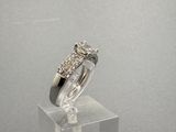 une photo d'une bague en diamant posée sur un socle transparent