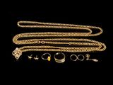 un gros plan sur une chaîne en or à laquelle sont accrochés une bague et un collier
