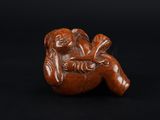 une petite figurine sculptée représentant un singe sur fond noir