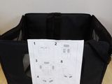 an empty black bag sitting on top of a wooden floor next to a wall