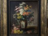 a painting of flowers in a vase on a table in front of a brick wall